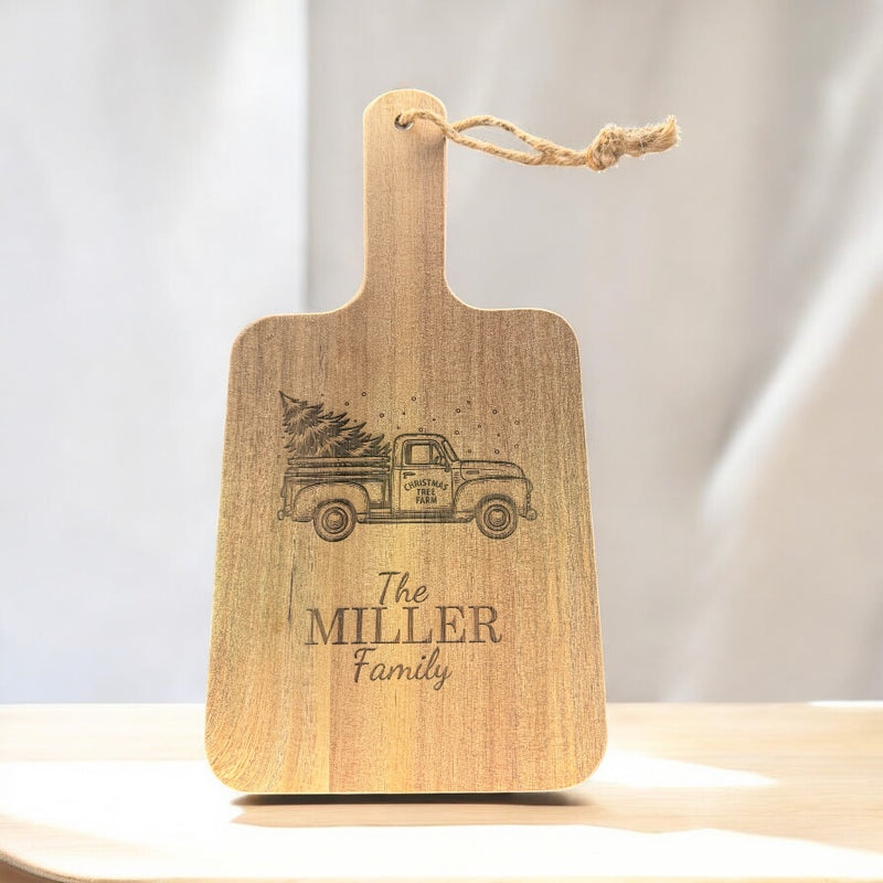 Wooden cutting board with engraved vintage truck and 'The MILLER Family' text on a light background